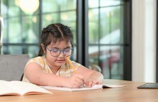 las chicas asiáticas están estudiando en tutoría, estudiando en línea en casa, las chicas están aburridas y cansadas de la tutoría. foto