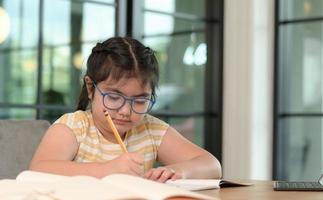 las chicas asiáticas están estudiando en tutoría, estudiando en línea en casa, las chicas están aburridas y cansadas de la tutoría. foto