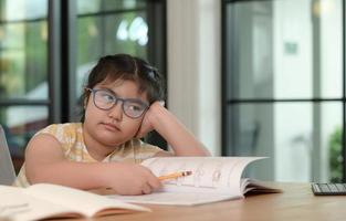 Asian girls are studying in tutoring, studying online at home, girls are bored and tired from tutoring. photo