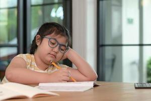 las chicas asiáticas están estudiando en tutoría, estudiando en línea en casa, las chicas están aburridas y cansadas de la tutoría. foto