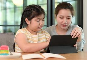 las chicas asiáticas estudian con un tutor, clases particulares en casa, hermanas y hermanas. foto