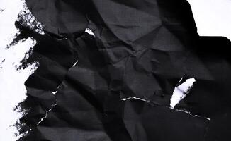 Black paper with white tears for the background. Crumpled paper texture with messy tears. photo