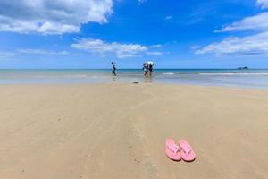 Pink sandals on the beautiful beach photo