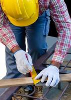 Man using a try square to mark and measure a wooden board photo