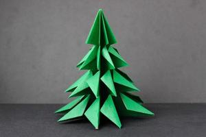 árbol verde de origami sobre un fondo negro foto