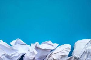 Crumpled paper on blue background with place for your design photo