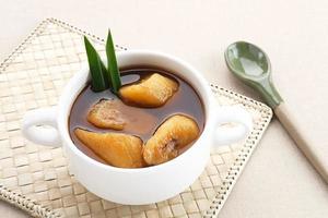 Setup Pisang is Indonesian traditional dessert made of banana, palm sugar boiled with cinnamon, pandan leaves and cloves. photo