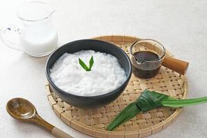 Bubur sumsum made from rice flour and coconut milk is traditional Indonesian porridge. Served with brown sugar syrup. Selected focus. photo
