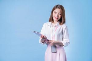 Image of young Asian businesswoman on blue background photo