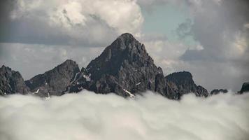 8k scherpe rotsachtige bergtop boven de wolken video