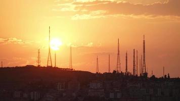 puesta de sol de 8k detrás de torres de antenas altas