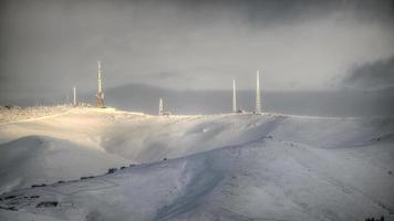 8k gsm en tv-zenderantennes op de besneeuwde bergtop in de winter video