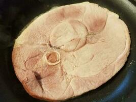 piece of ham frying in a pan photo