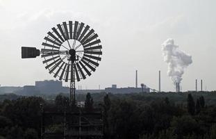 Windmill with factory in the background photo