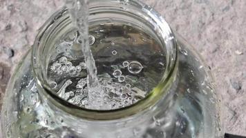 Pouring clean water into a glass jar close-up angle view. Dynamic motion in video. video