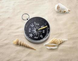 brújula en arena de mar. destino de viaje y concepto de navegación foto