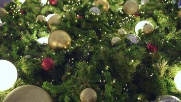 Christmas tree decorated with garlands balls in sparkling lights. video