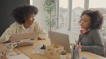 klaslokaal met diverse leerlingen van gelukkig Afro-Amerikaanse studenten en leraar die samen activiteiten doen. de leraar geeft les, begeleidt en praat met de kinderen in divers. video