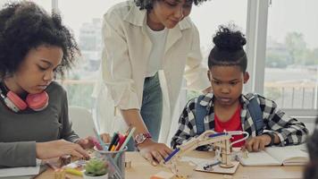 Classroom with diverse learners of happily African American students and teacher doing activities together. The teacher is teaching, guiding and talking to the children in diverse. video