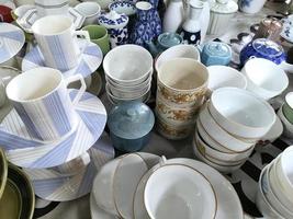 Heap of different crockery, porcelain and ceramic dishes. Bowl, plates and cups. Close up photo