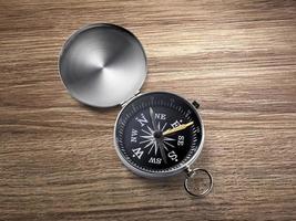 compass on the brown wooden table background photo