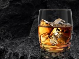 vaso de whisky, anidado sobre fondo de carbón negro. renderizado 3d foto