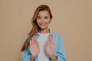 bastante alegre modelo haciendo señal de stop usando las manos foto