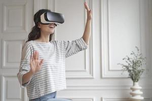 joven mujer feliz con auriculares de realidad virtual disfrutando de una experiencia de compra divertida en un mundo aumentado foto