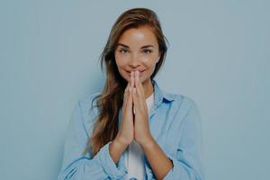 Happy calm grateful model female folding hands for pray Namaste gesture photo