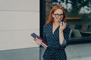 Beautiful smiling business woman using speakerphone or virtual voice assistant on mobile phone photo