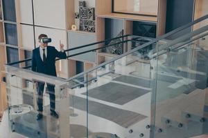 CEO of gaming company testing prototype of VR headset while walking around office center lobby photo