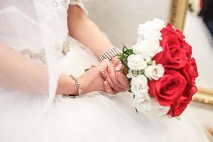 a bouquet of red roses in bride's hands photo