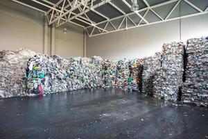 Plastic bales at the waste processing plant. Separate garbage collection. Recycling and storage of waste for further disposal. Business for sorting and processing of waste. photo