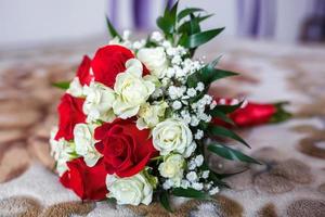 bouquet of red and white roses with wedding rings photo