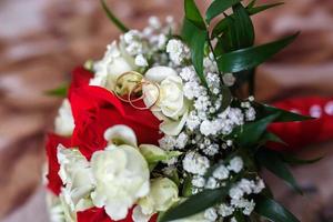 bouquet of red and white roses with wedding rings photo