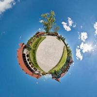 Little planet.  Spherical aerial view  in forest near vacation home in nice day with nice clouds photo