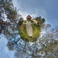 pequeño planeta vista aérea esférica en el bosque cerca de la casa de vacaciones en un buen día con nubes agradables foto