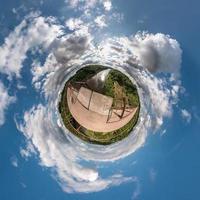 pequeño planeta vista esférica en un campo en un hermoso día con bonitas nubes foto