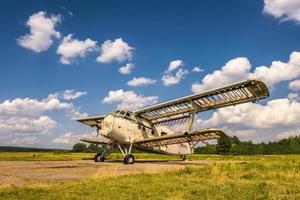 viejo avión destruido en el campo en un día soleado foto