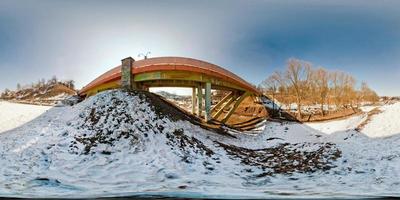Winter panorama in the snow-covered forest near the bridge in nice sunny evening. Full spherical 360 by 180 degrees seamless panorama in equirectangular projection. Skybox for Virtual reality content photo