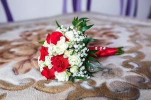 bouquet of red and white roses with wedding rings photo