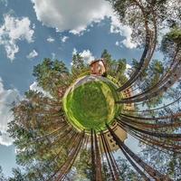 pequeño planeta vista aérea esférica en el bosque cerca de la casa de vacaciones en un buen día con nubes agradables foto