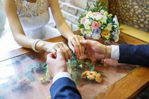 The groom holds the hands of his bride on their wedding day photo