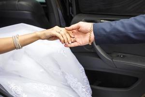 The groom holds the hands of his bride on their wedding day photo