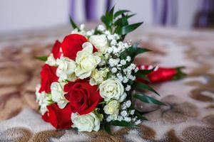 bouquet of red and white roses with wedding rings photo