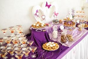 View of the served for decorated wedding dinner table with white violet color. photo