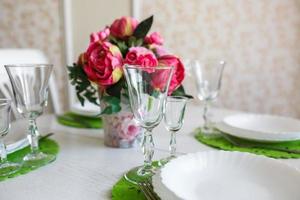 ramo de flores de peonías rosas en una mesa con cubiertos foto