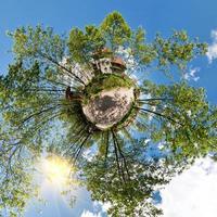 pequeño planeta vista aérea esférica en el bosque cerca de la casa de vacaciones en un buen día con nubes agradables foto