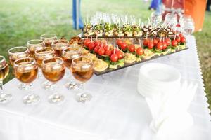 Decorated beautiful table with candles at the celebration. Wedding. Birthday. Romantic dinner in garden. Anniversary. Beautiful glassware. Sunlight. photo