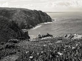 Beautiful view of a sea surrounded by cliffs under a bright sky photo